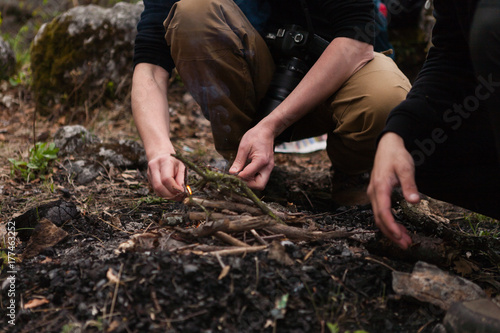 Male hands burning wood branches