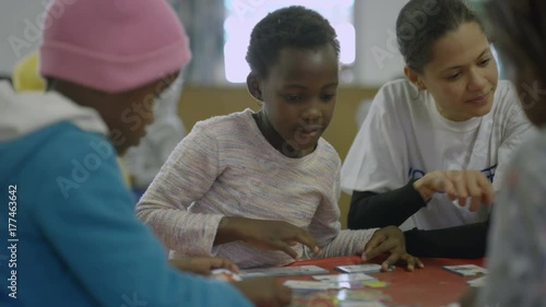 Charity worker playing with children from a poor African community - EDITORIAL photo