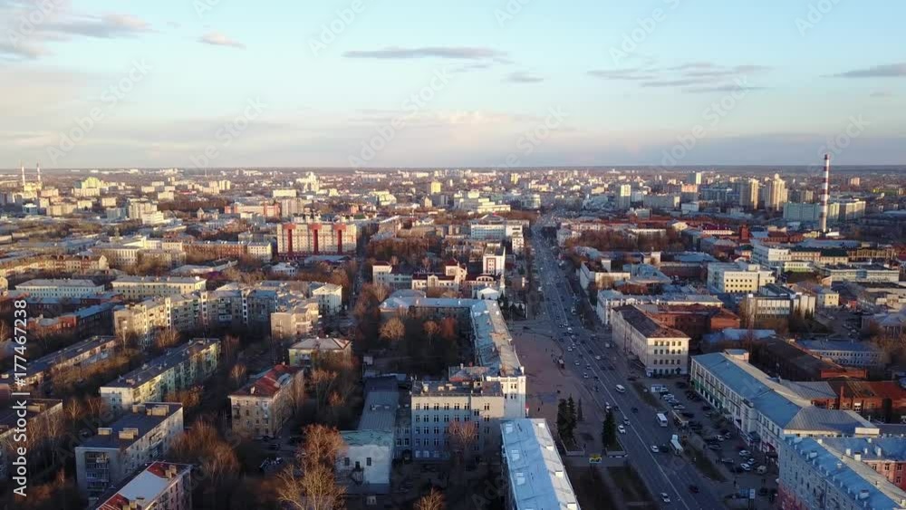 aerial flight over the city avenue in the summer evening during sunset.