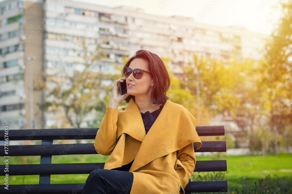 Young elegant woman making a phone call in the park. Young elegant woman making a phone call in the park.