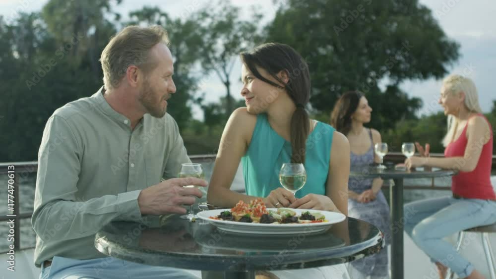 Couple on romantic vacation relaxing on a boat trip with wine & canapés Couple on romantic vacation relaxing on a boat trip with wine & canapés