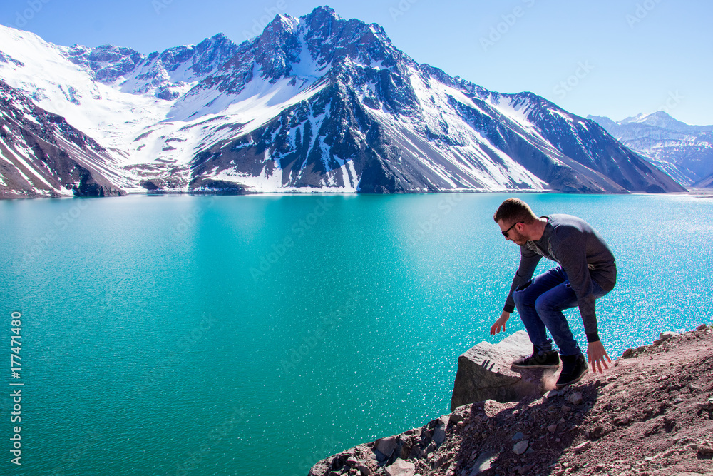 Naklejka premium Time to relax sitting on the ground an looking at the beauty of the Embalse El Yeso in Chile
