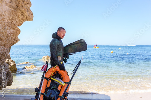 Underwater hunter preparing to dive. Underwater fishing in Atlantic Ocean.