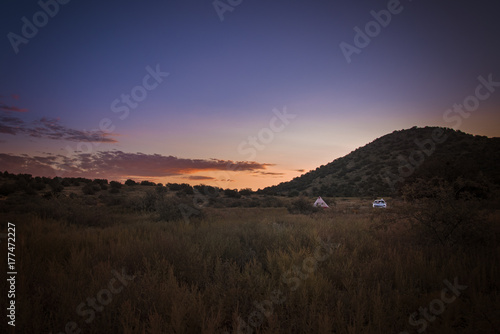 A tent in a the far distance during sunset
