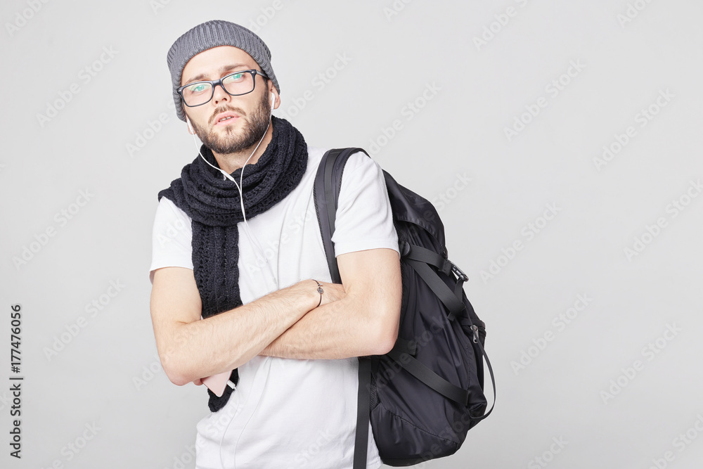 Close up portrait of serious gloomy European man with stylish clothes posing against white wall background. Handsome guy with dark beard frowning his face showing his dissatisfaction and bad mood. Close up portrait of serious gloomy European man with stylish clothes posing against white wall background. Handsome guy with dark beard frowning his face showing his dissatisfaction and bad mood.