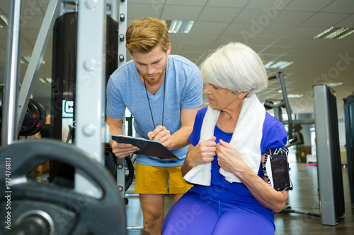 senior woman doing sport exercises with coach or personal trainer photo