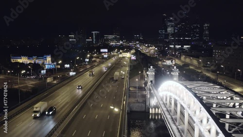 Aerial view of Luzhniki Metro Bridge, also known as Metromost, heavy traffic at night.Moscow river and city skyline during sunset. Big city life concept. Big city life concept.