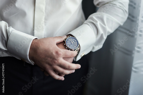 businessman clock clothes, businessman checking time on his wristwatch. men's hand with a watch, watch on a man's hand, the fees of the groom, preparation for work, putting the clock on the hand