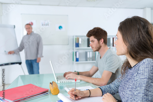 international students and teacher standing at white board at lecture
