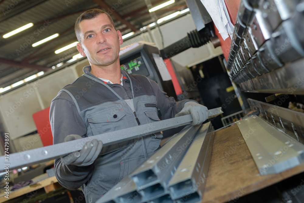 man working with metal bars in factory man working with metal bars in factory