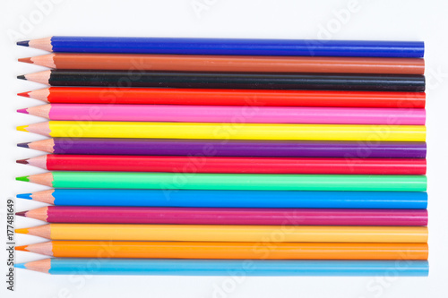 Colored pencils are horizontally positioned on a white background. A drawing tool. Wooden objects for creativity.