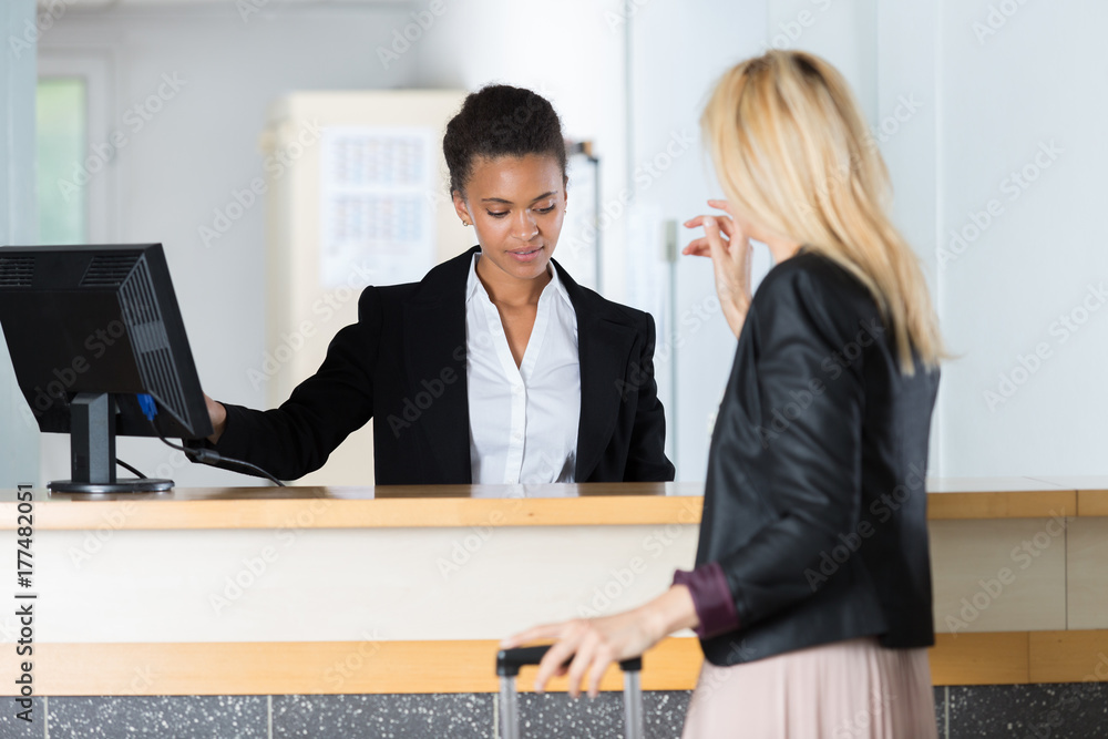 Lady checking in at hotel reception Lady checking in at hotel reception