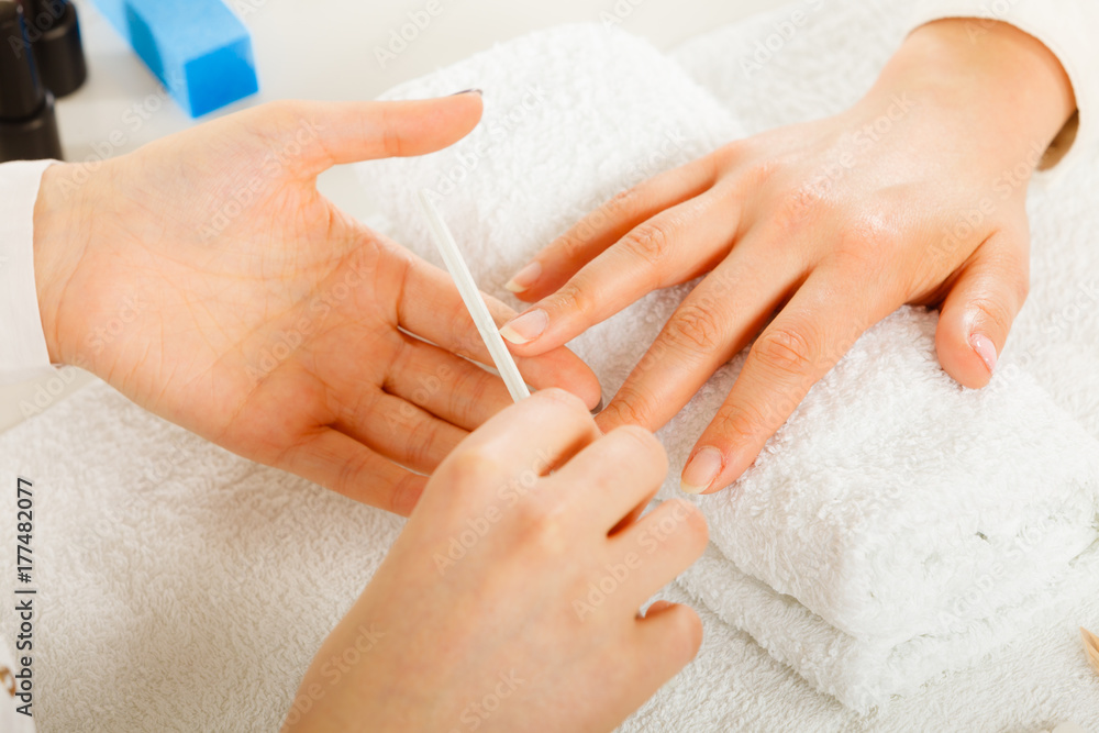 Woman getting manicure done file nails Woman getting manicure done file nails