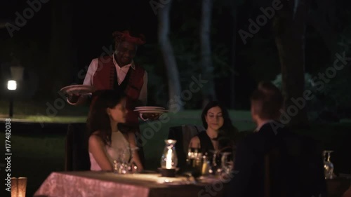 Wallpaper Mural  Guests on African vacation being served at dinner table by friendly waiter Torontodigital.ca