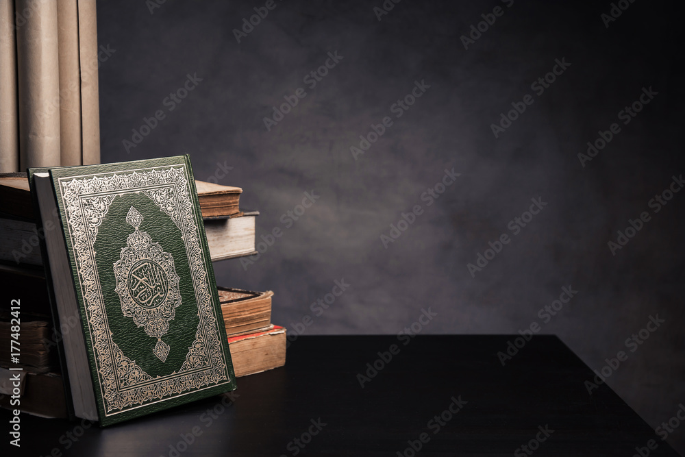 Naklejka premium Koran - holy book of Muslims ( public item of all muslims ) on the table , still life