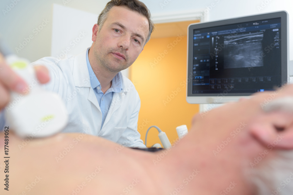 doctor placing ultrasound probe on male patients chest - obrazy, fototapety, plakaty 