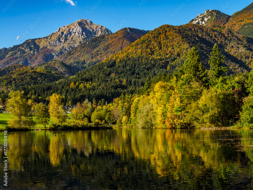 Fototapeta premium Mountains in autumn colors reflecting Lake Crnava by Preddvor, Slovenia