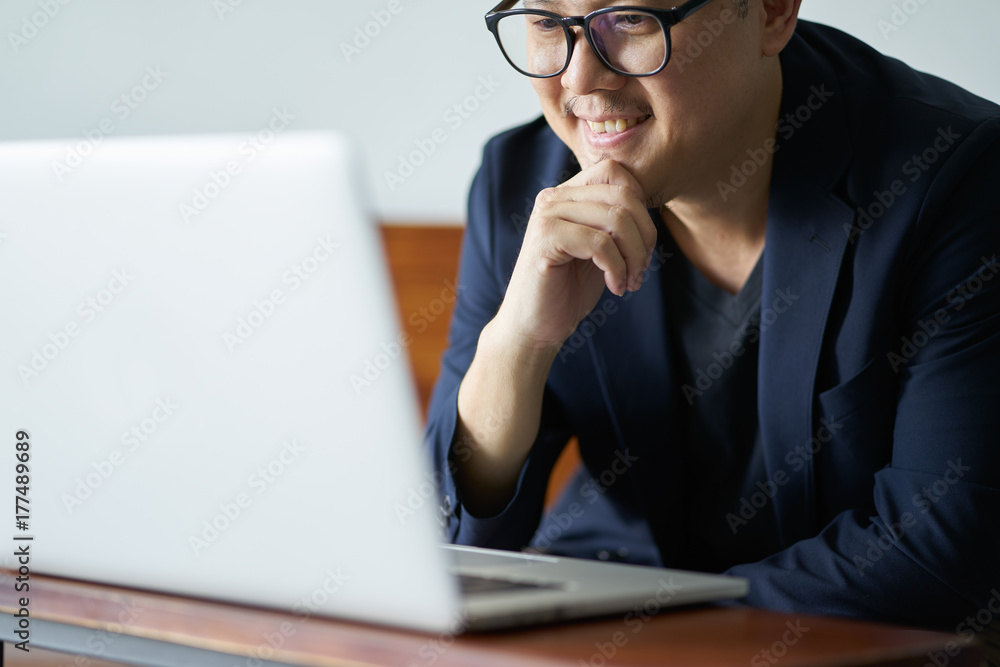Successful businessman smile in front of the computer , selective focusing .
