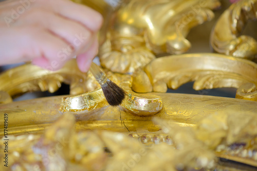 Photos Gold leaf being brushed onto frame