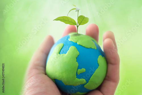 Planting tree in green globe , Environment conservation ,CSR Abbreviation or Corporate Social Responsibility