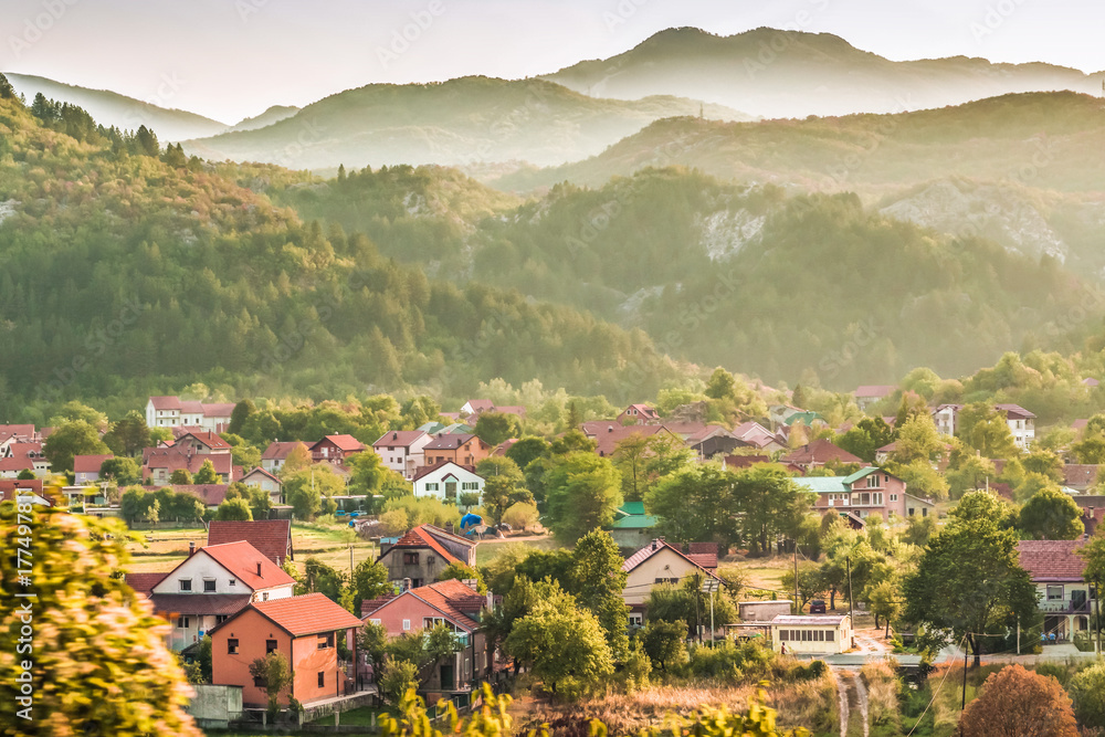 A small village and buildings in the green Balkan mountains of Montenegro.