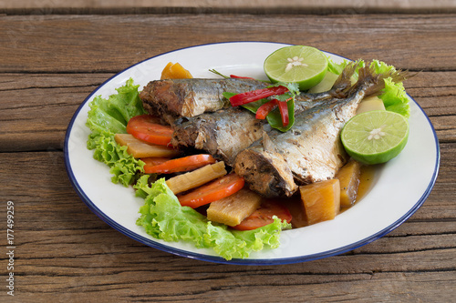 Mackerel boiled sweet and salted on white dish Thai food on old wooden table .