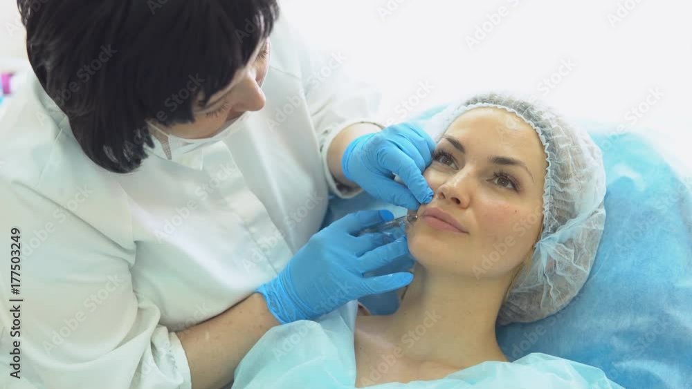 Facial rejuvenation procedure female doctor injects injections of