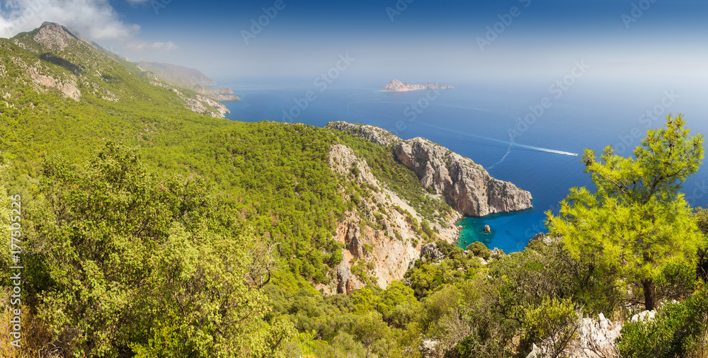 Idyllic Mediterranean landscape with a solitary bay of azure color and mountains covered with pine forest, travel in paradise concept