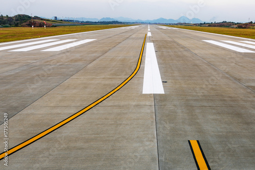 Runway  airstrip in the airport terminal with marking on blue sky with clouds background. Travel aviation concept.