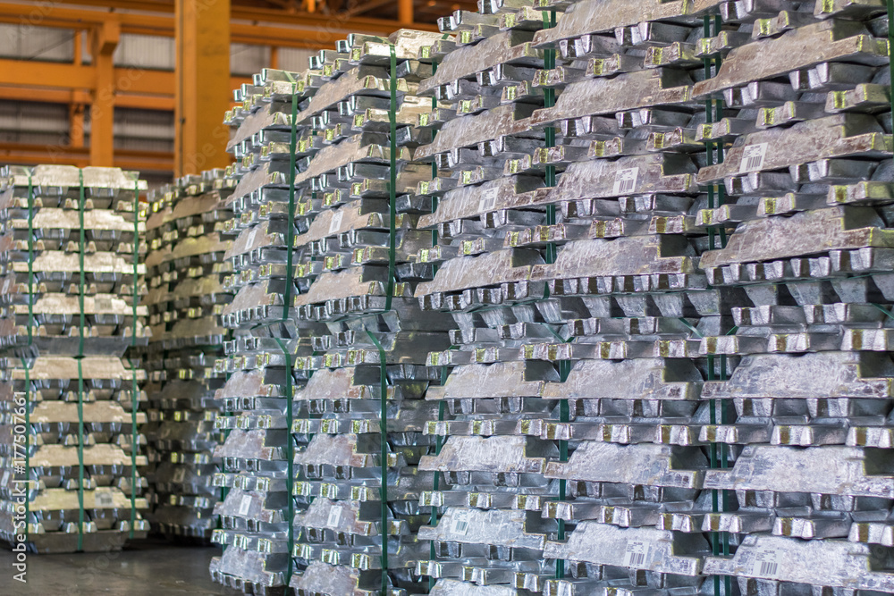 Aluminum ingot bar stacked in warehouse. Raw material for industrial concept. General cargo warehouse concept Aluminum ingot bar stacked in warehouse. Raw material for industrial concept. General cargo warehouse concept