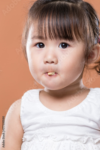 Cute baby girl eating biscuit