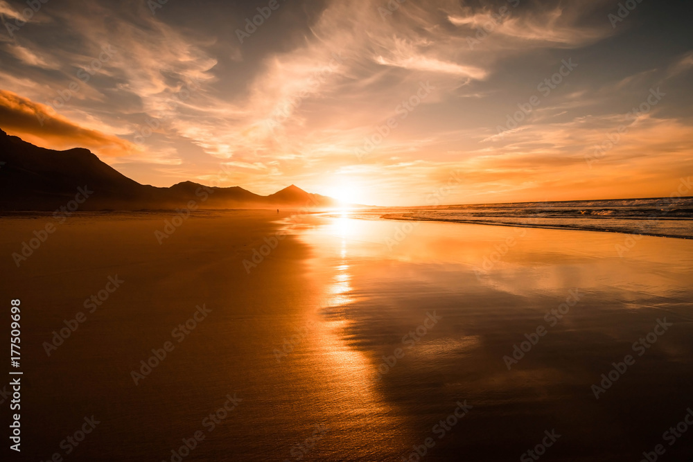 Amazing beach sunset with endless horizon and hills, reflection in the background Amazing beach sunset with endless horizon and hills, reflection in the background