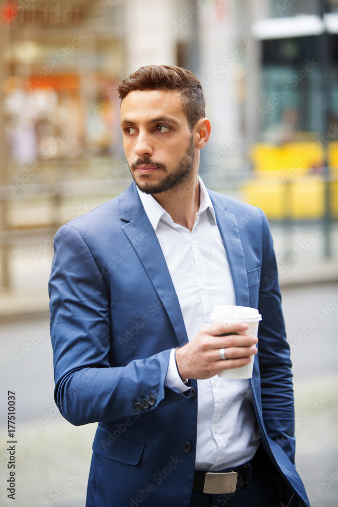 businessman standing in the street holding a cup businessman standing in the street holding a cup
