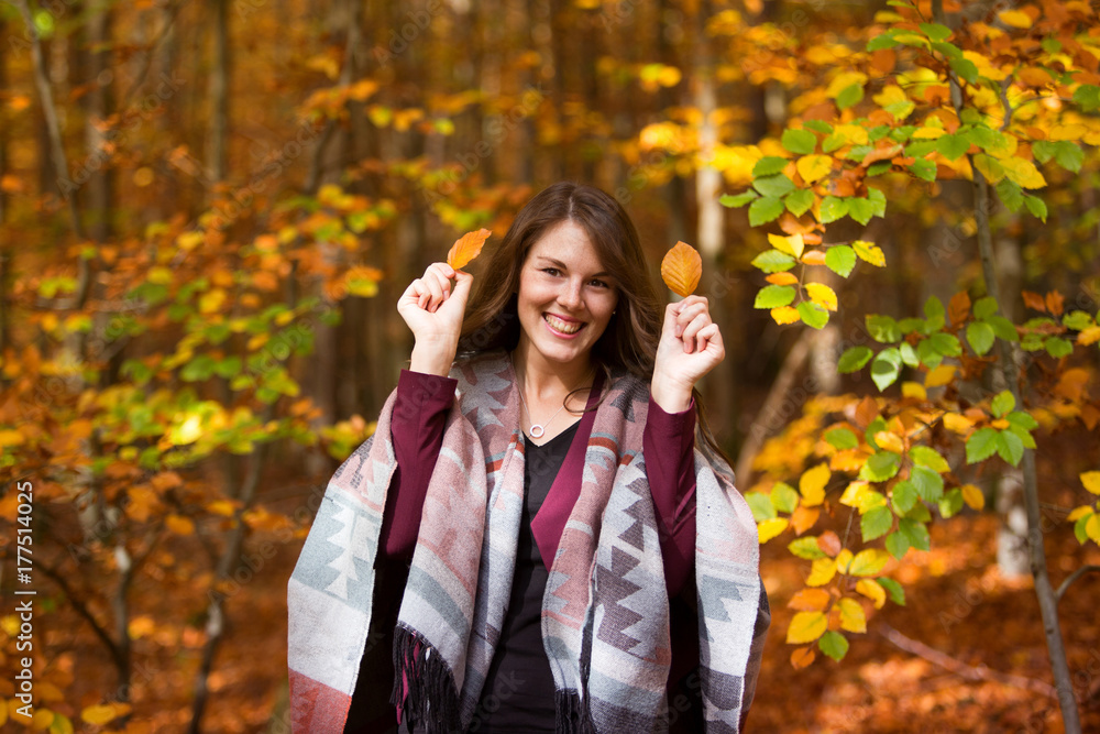 young brunette woman in forest holding leaves young brunette woman in forest holding leaves