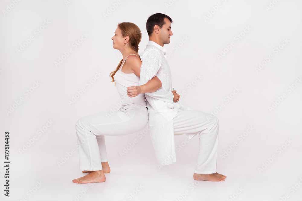 Yoga class paired with the coach. Man and woman doing the exercise. Yoga class paired with the coach. Man and woman doing the exercise.