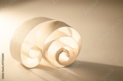 Abstract curl of paper. Light and shadow on a golden background.