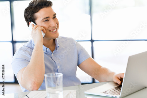 Wallpaper Mural Confident young man in smart casual wear holding phone Torontodigital.ca