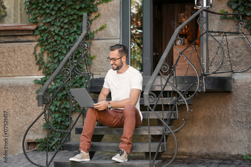 Handsome man with laptop si...