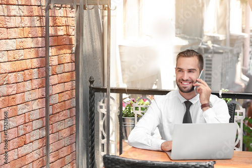 Elegant man with laptop tal...