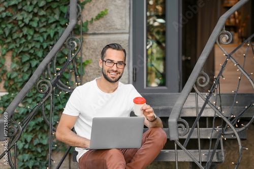 Handsome man with laptop si...