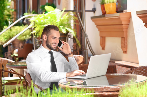 Elegant man with laptop tal...