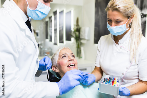 Beautiful senior woman at dentist having dental treatment at dentist s office.