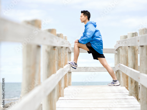 Fototapeta Naklejka Na Ścianę i Meble -  Young man doing exercise at the beach