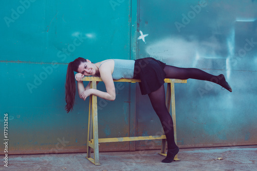 Young ballerina in black clothes training in front of the turquoise blue door