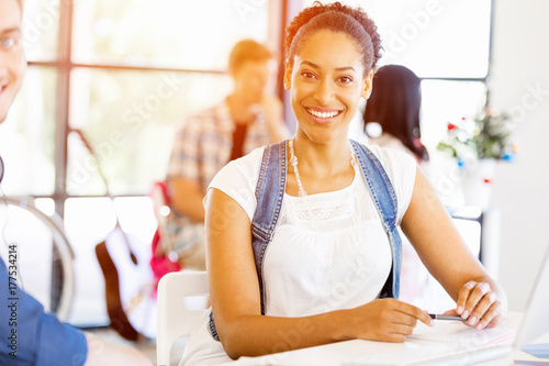 Portrait of smiling afro-american office worker sitting in offfice Free Download Portrait of smiling afro-american office worker sitting in offfice - GFXLoad