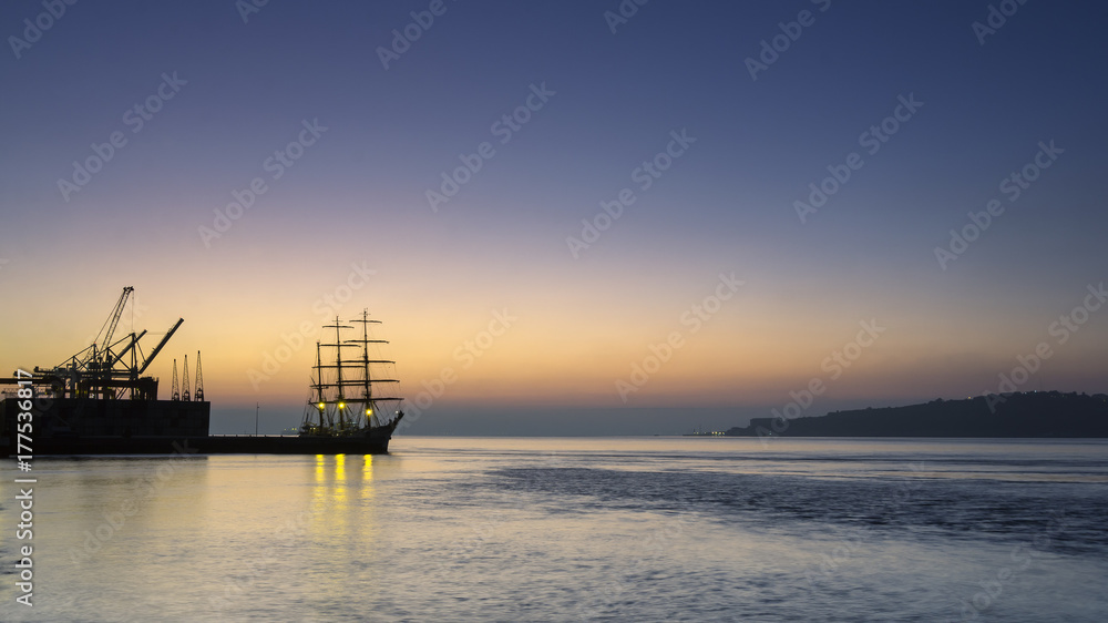 Tagus river, cranes and ship in a foggy dawn