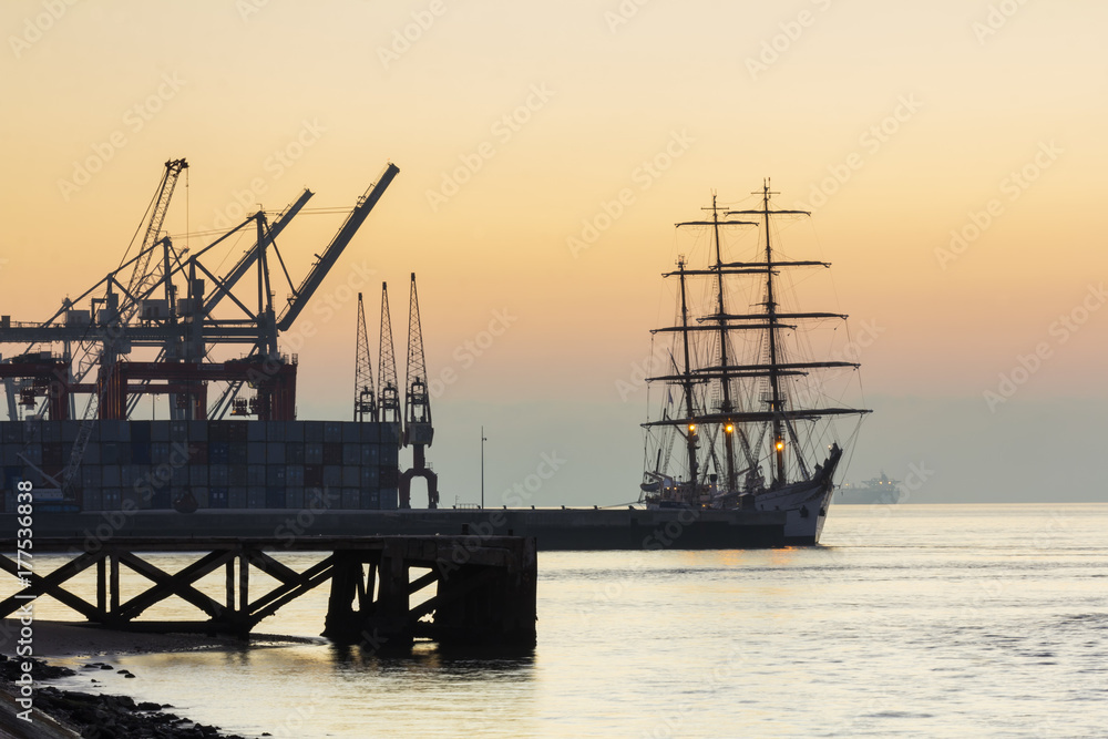Tagus river, cranes and ship in a foggy dawn