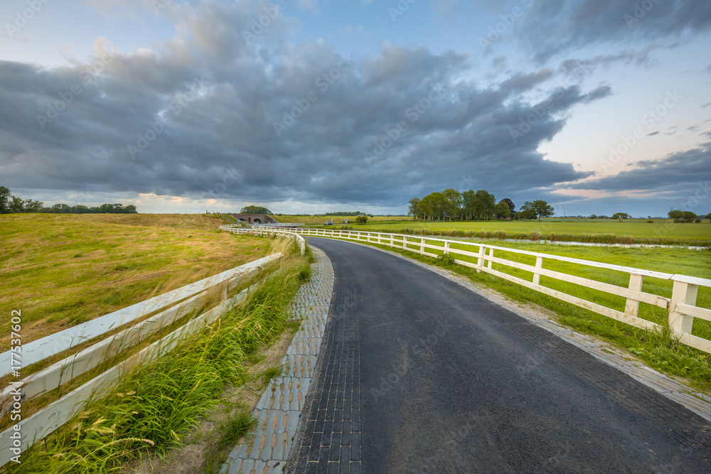 Fototapeta premium Curved Asphalt country road in dutch countryside