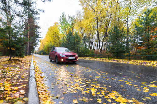 Red car on autumn road