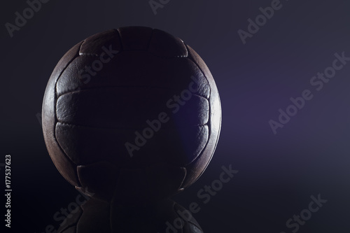 Old football leather ball on a black background © dima